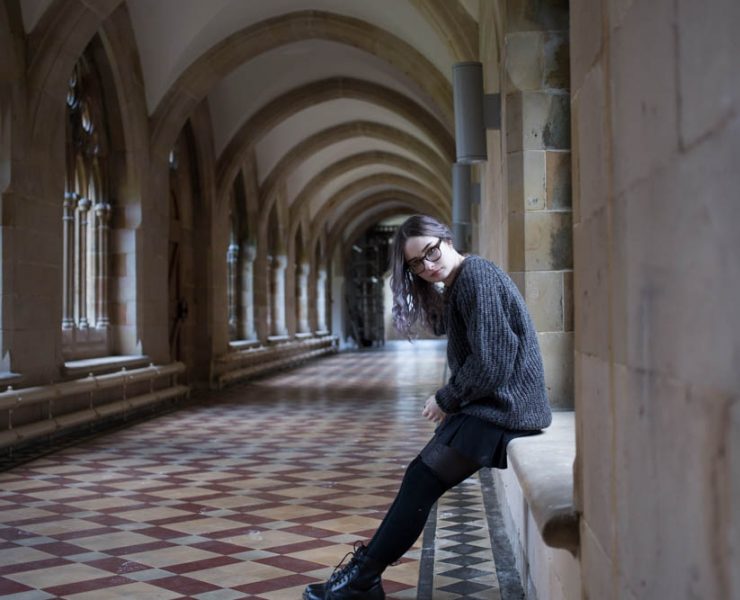 girl sitting on windowsill in hogwarts corridor