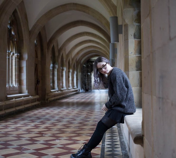 girl sitting on windowsill in hogwarts corridor