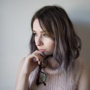 girl holding glasses and wearing pink fluffy jumper