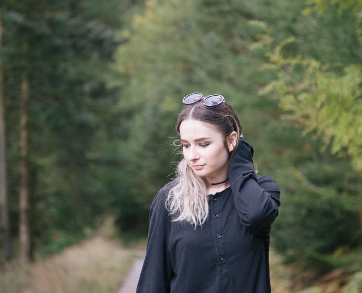 girl standing in forest wearing all black