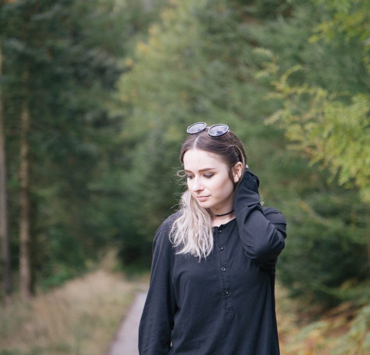 girl standing in forest wearing all black