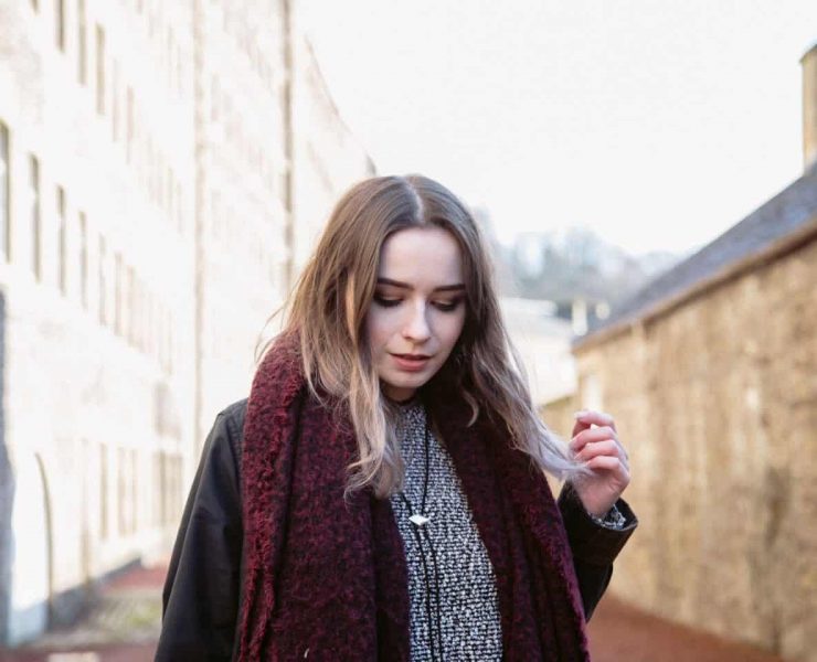 girl stood amongst old buildings in new lanark heritage site