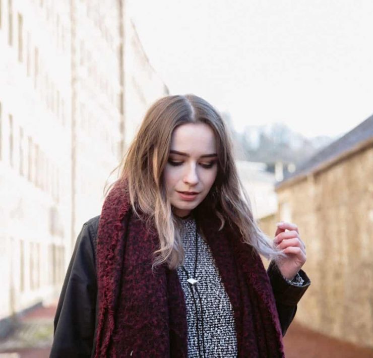 girl stood amongst old buildings in new lanark heritage site