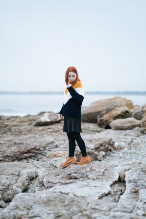 girl standing on the beach in cost chenille jumper