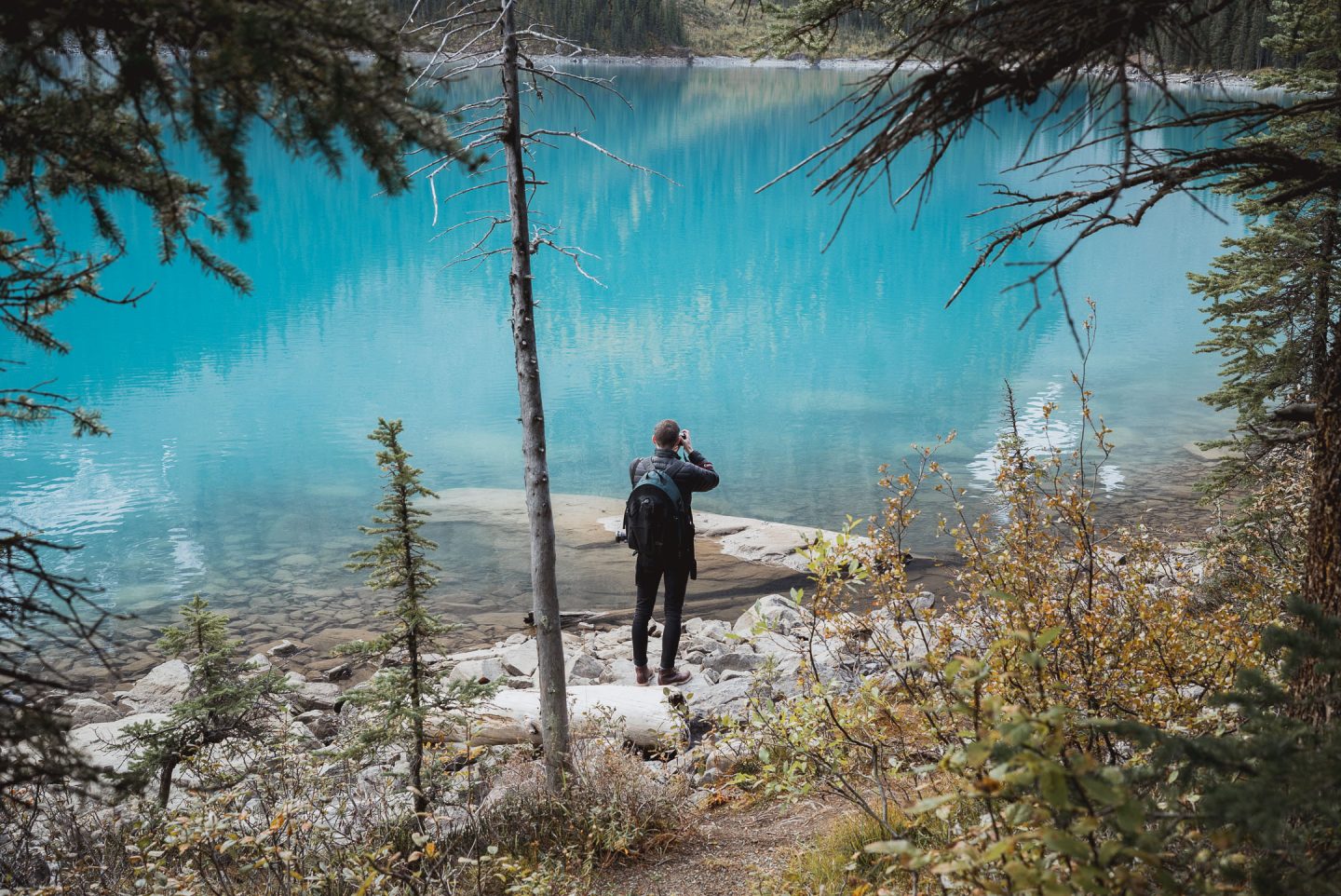 man standing at the edge of moraine lake banff