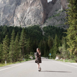 girl stood in road in front of mountains in italy