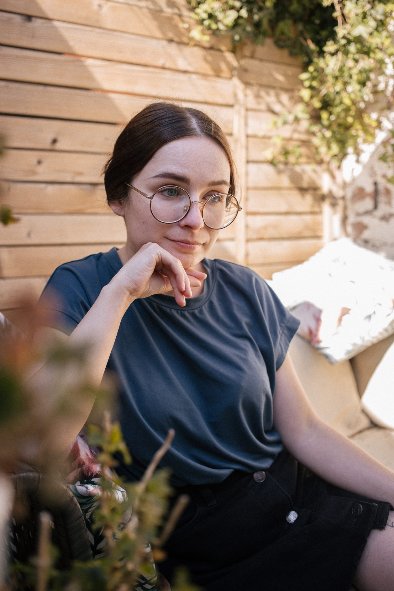 girl wearing navy blue t shirt and black denim skirt sat in garden